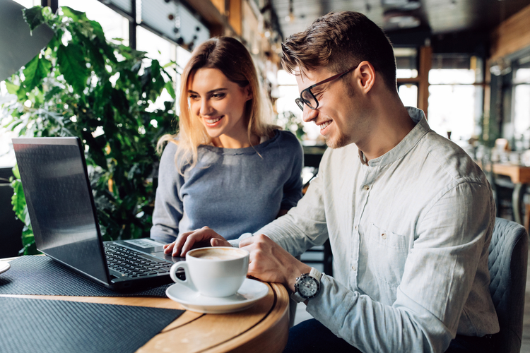 Two people look at laptop